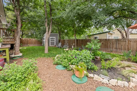 a view of a house with a yard and large trees