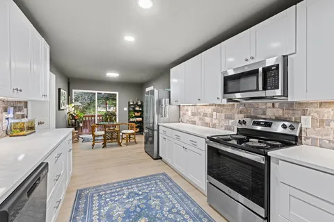 a kitchen with stainless steel appliances a stove sink microwave and cabinets