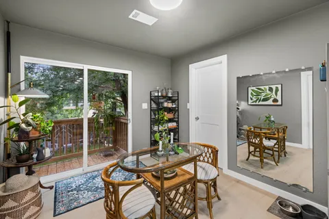 a dining room with furniture and a floor to ceiling window