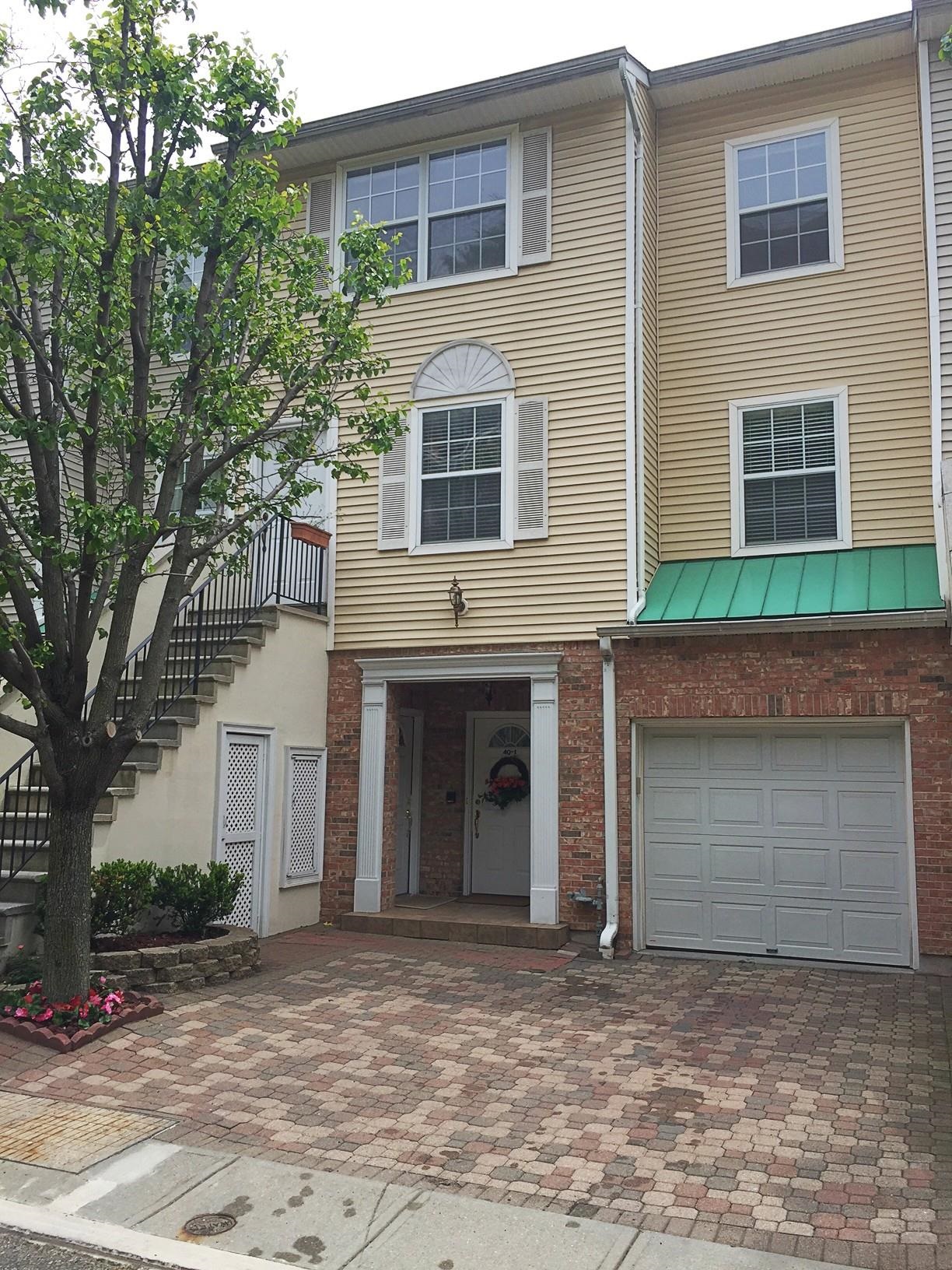 54 Bergen Ridge Road, Unit 1 North Bergen, NJ 07047 - Photo 16 of 16 a front view of a house with a yard and garage