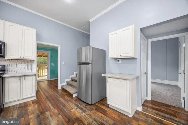 a view of a hallway with wooden floor and entryway
