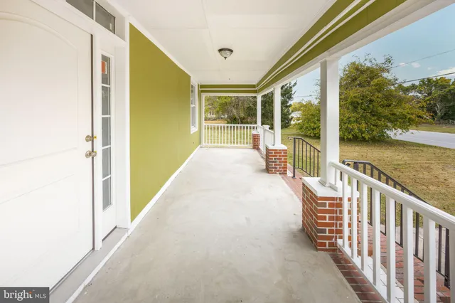 a view of empty room with wooden floor and ceiling fan