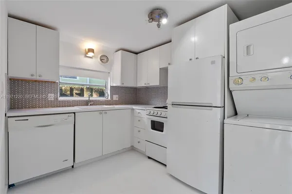a kitchen with white cabinets and white appliances