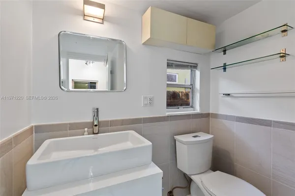 a bathroom with a sink mirror and toilet