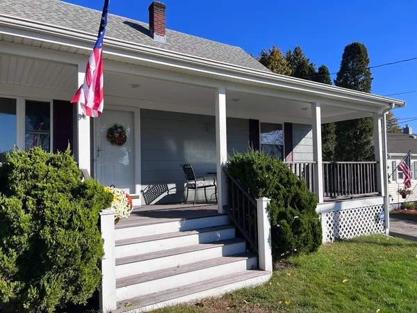 a view of a house with potted plants and a table and chairs