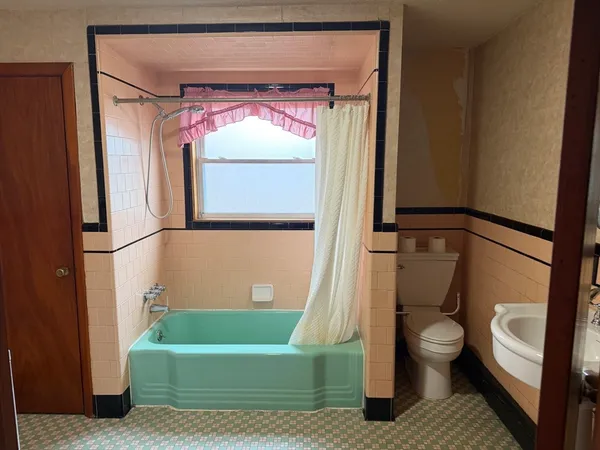 a bathroom with a toilet a sink and bathtub