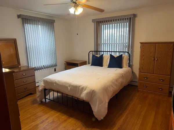 a bedroom with a bed and wooden floor