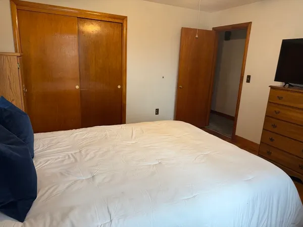 a bedroom with a bed and a flat tv screen