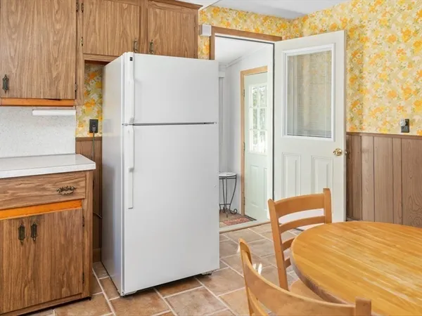 a bedroom with a bed and a refrigerator