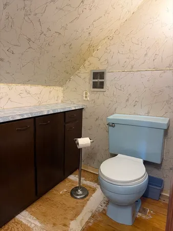 a bathroom with a granite countertop toilet and a sink