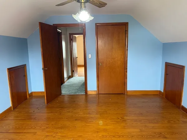 an empty room with wooden floor and closet
