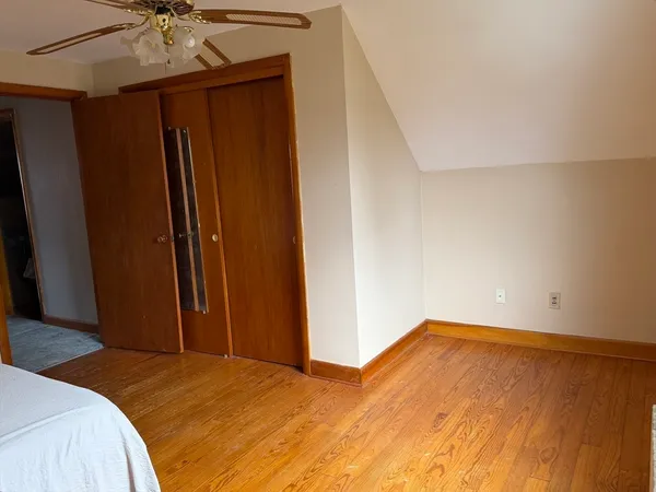 a bedroom with a bed and a ceiling fan