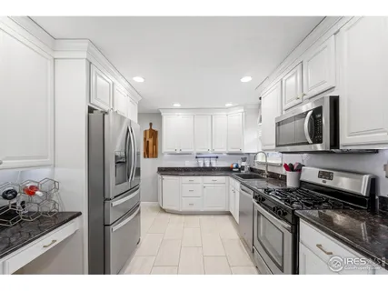 a kitchen with stainless steel appliances granite countertop a refrigerator stove microwave and sink
