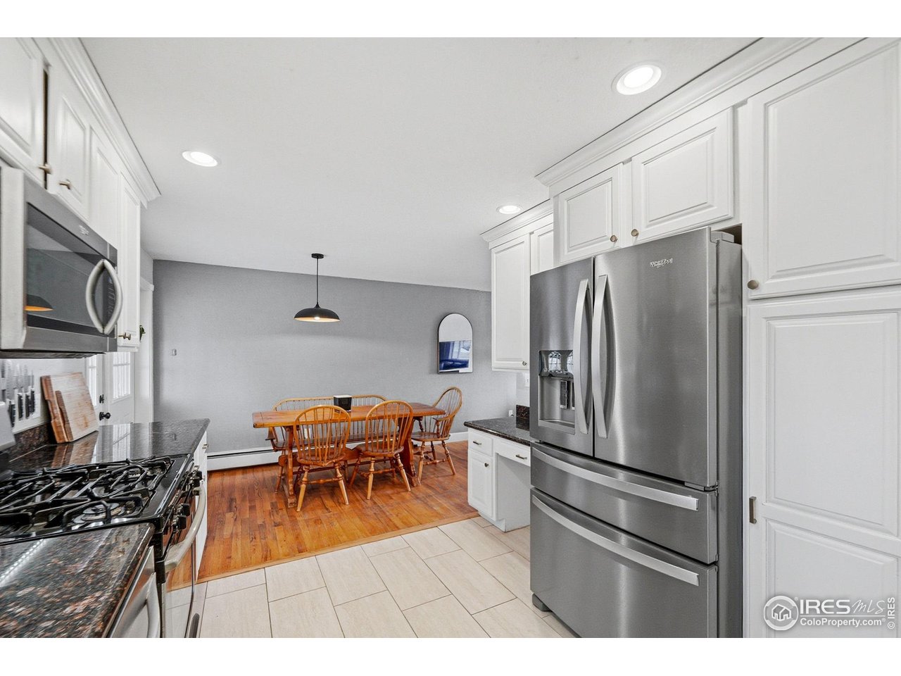 6034 South Steele Street Centennial, CO 80121 - Photo 8 of 46 a kitchen with stainless steel appliances a refrigerator a stove a sink a dining table and chairs