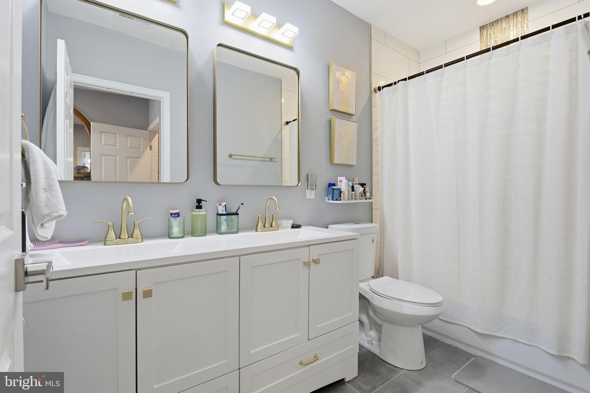 236 South Clinton Street Baltimore, MD 21224 - Photo 16 of 34 a bathroom with a sink a toilet and a mirror