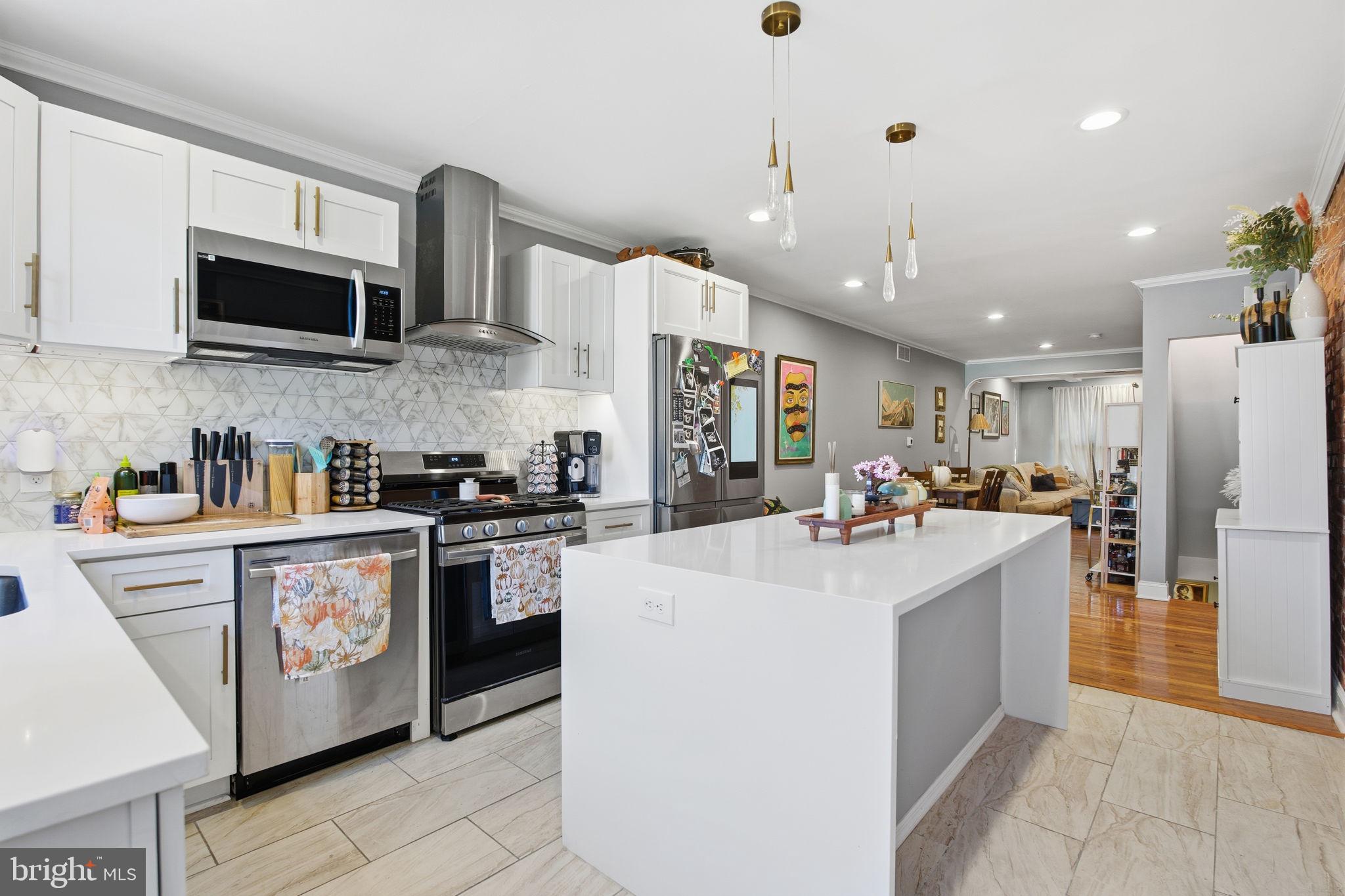 236 South Clinton Street Baltimore, MD 21224 - Photo 7 of 34 a kitchen with stainless steel appliances kitchen island granite countertop a sink and a refrigerator