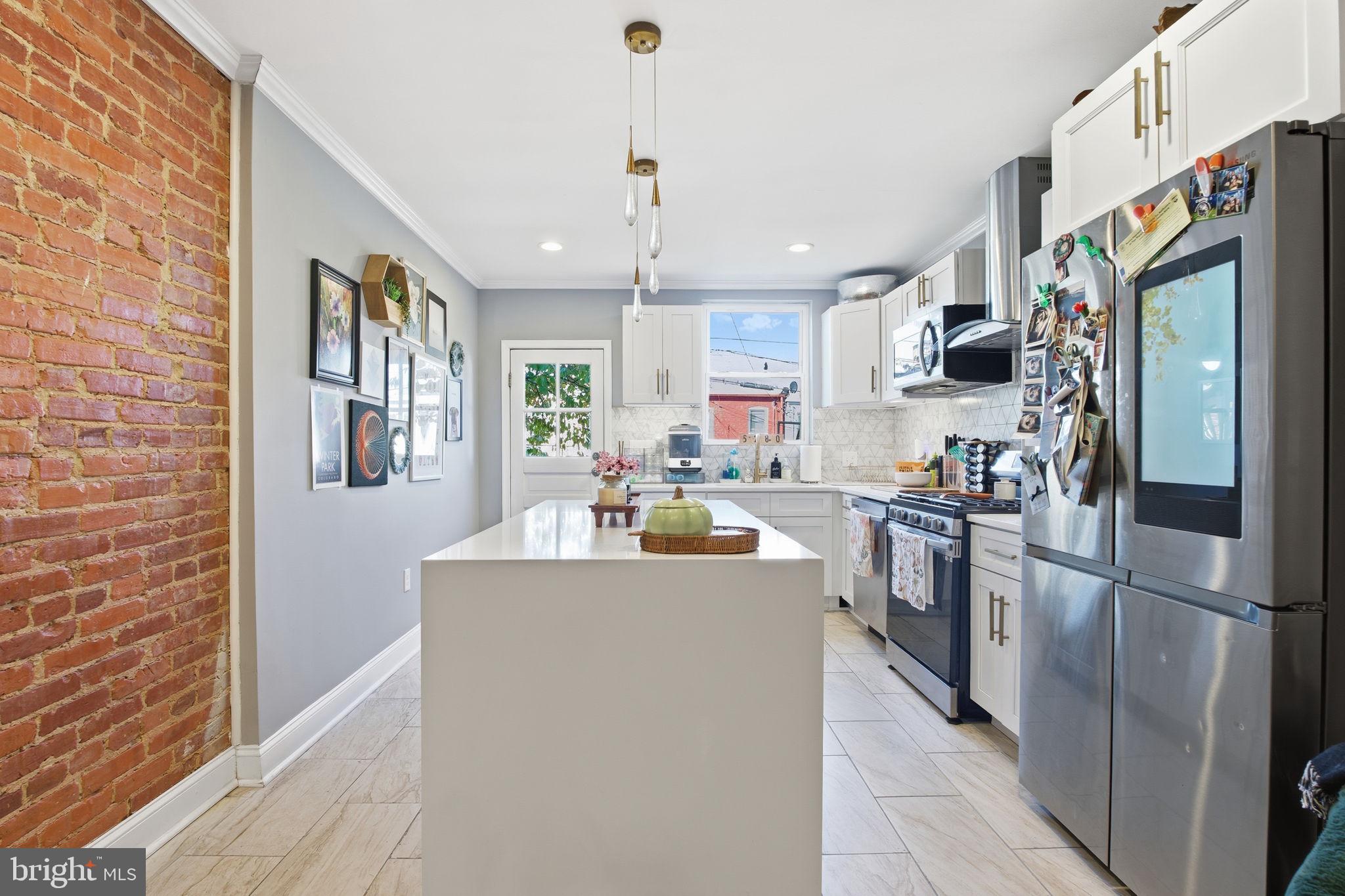 236 South Clinton Street Baltimore, MD 21224 - Photo 9 of 34 a kitchen with stainless steel appliances granite countertop a refrigerator a sink dishwasher a oven with white cabinets and wooden floor