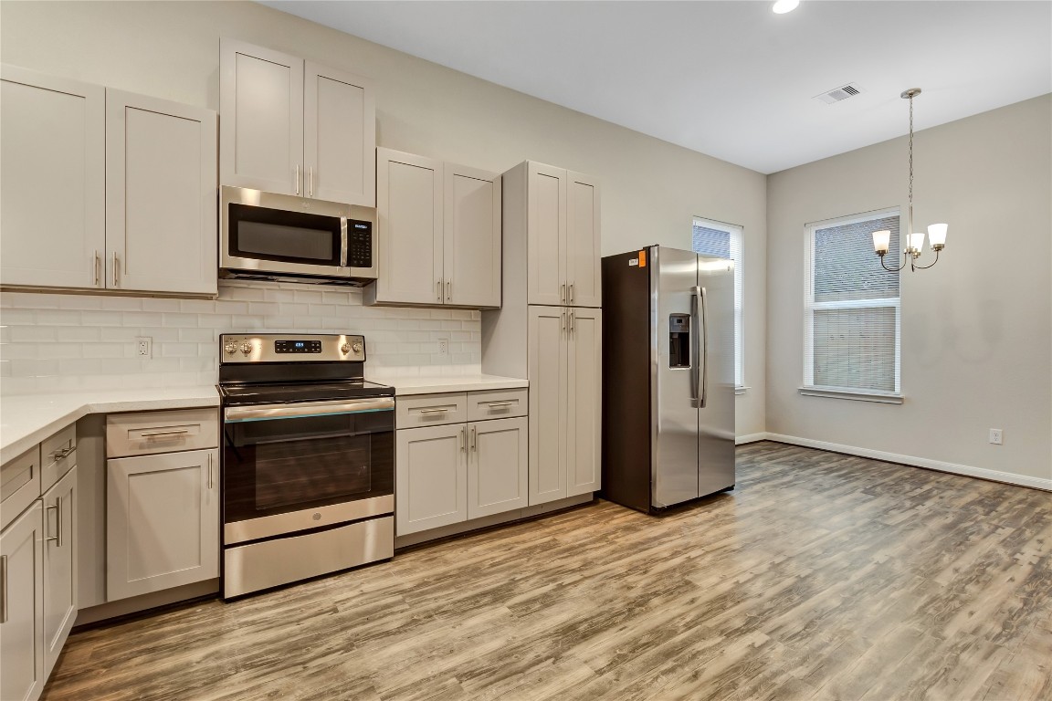 21 Latham Street, Unit D Houston, TX 77011 - Photo 3 of 8 a kitchen with stainless steel appliances a refrigerator stove and microwave