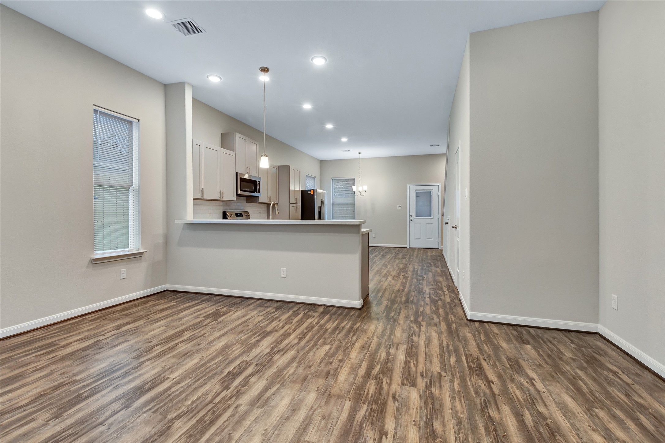 21 Latham Street, Unit D Houston, TX 77011 - Photo 4 of 8 a view of a kitchen with wooden floor and electronic appliances