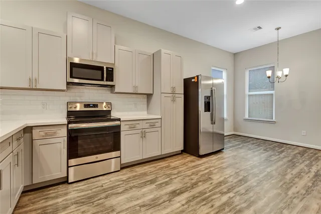 a kitchen with stainless steel appliances a refrigerator stove and microwave