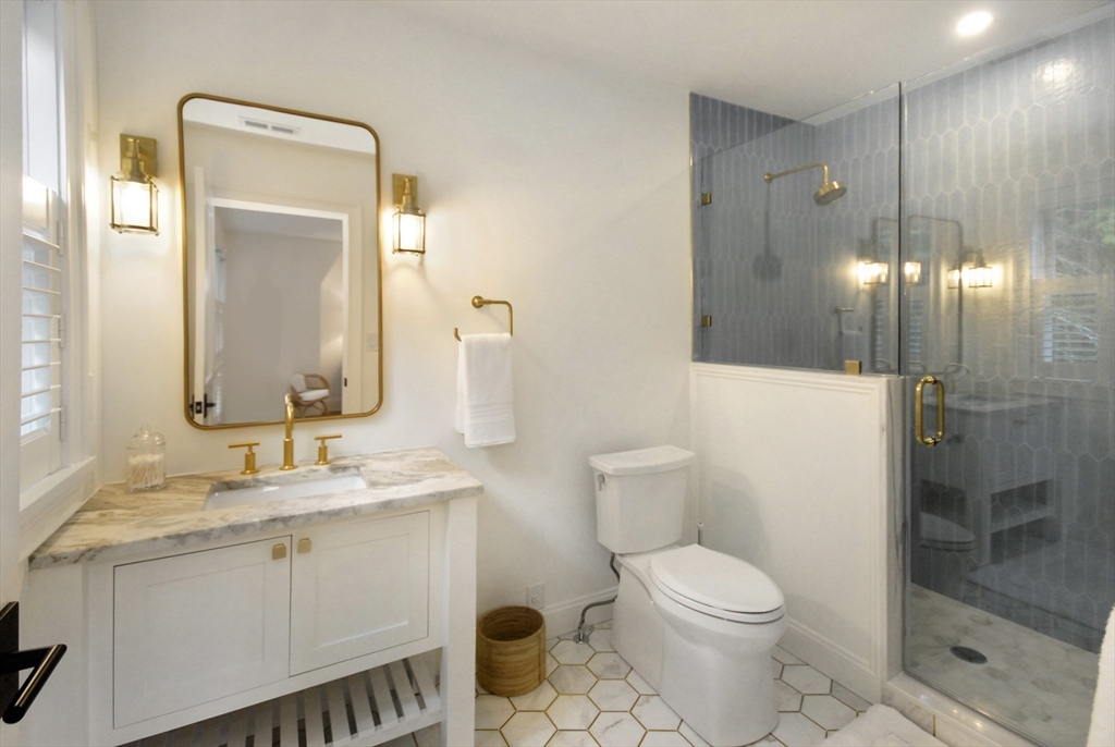 11 Williams Road Concord, MA 01742 - Photo 30 of 42 a bathroom with a toilet a sink a glass door a shower and a mirror