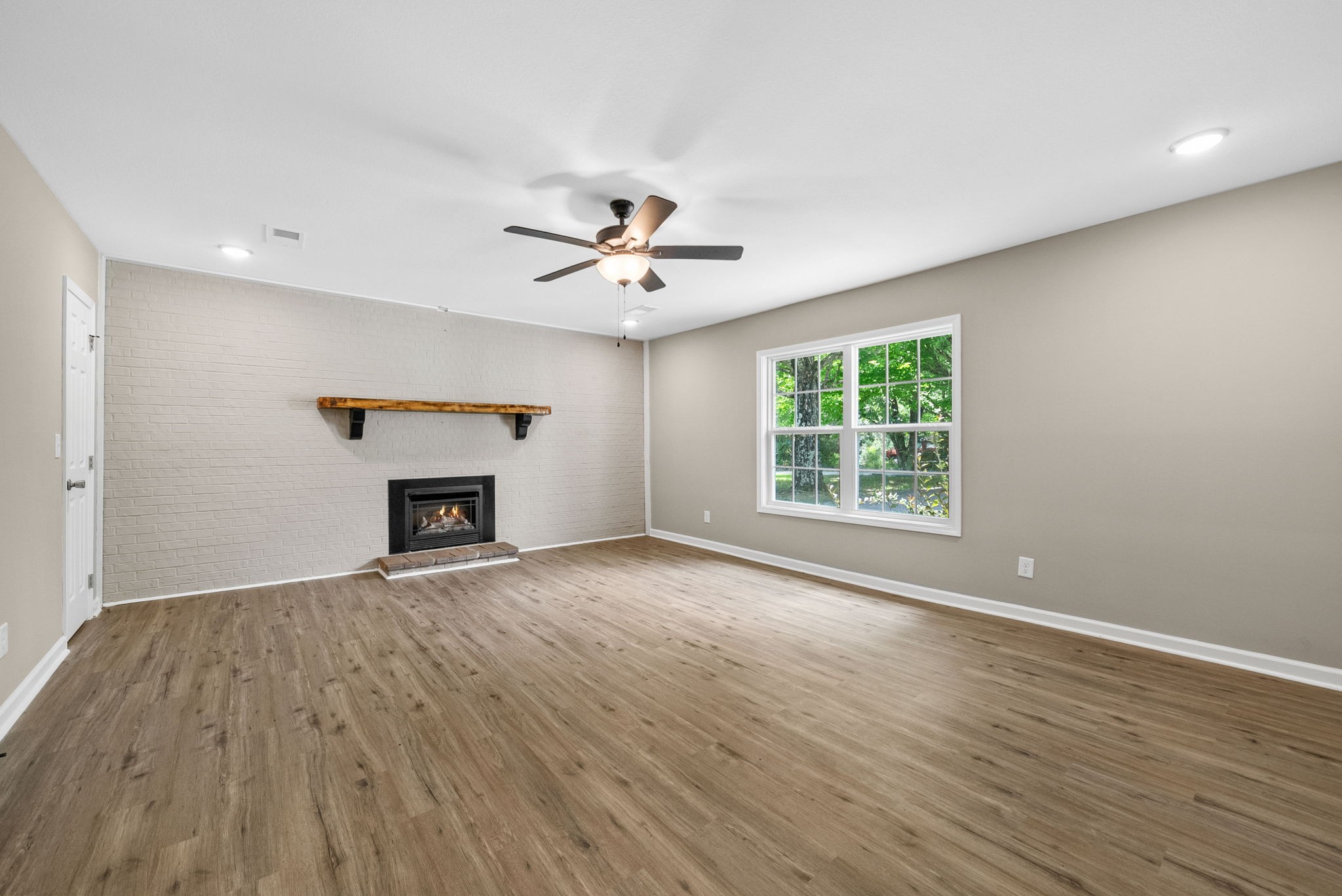 138 Walker Ridge Road Big Rock, TN 37023 - Photo 13 of 42 an empty room with windows a fireplace and wooden floor