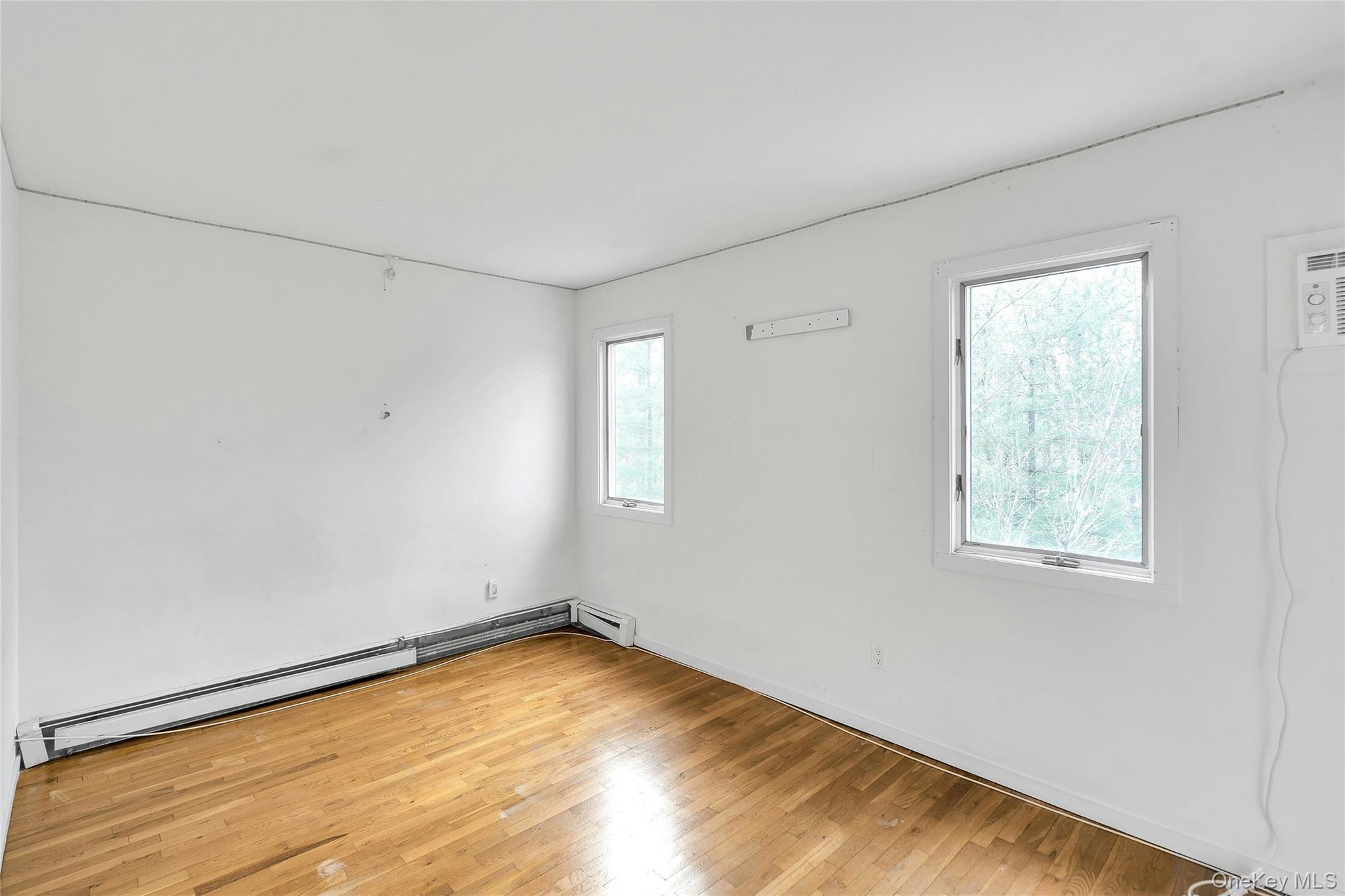 23 Bellows Terrace Hampton Bays, NY 11946 - Photo 20 of 31 a view of empty room with wooden floor and fan