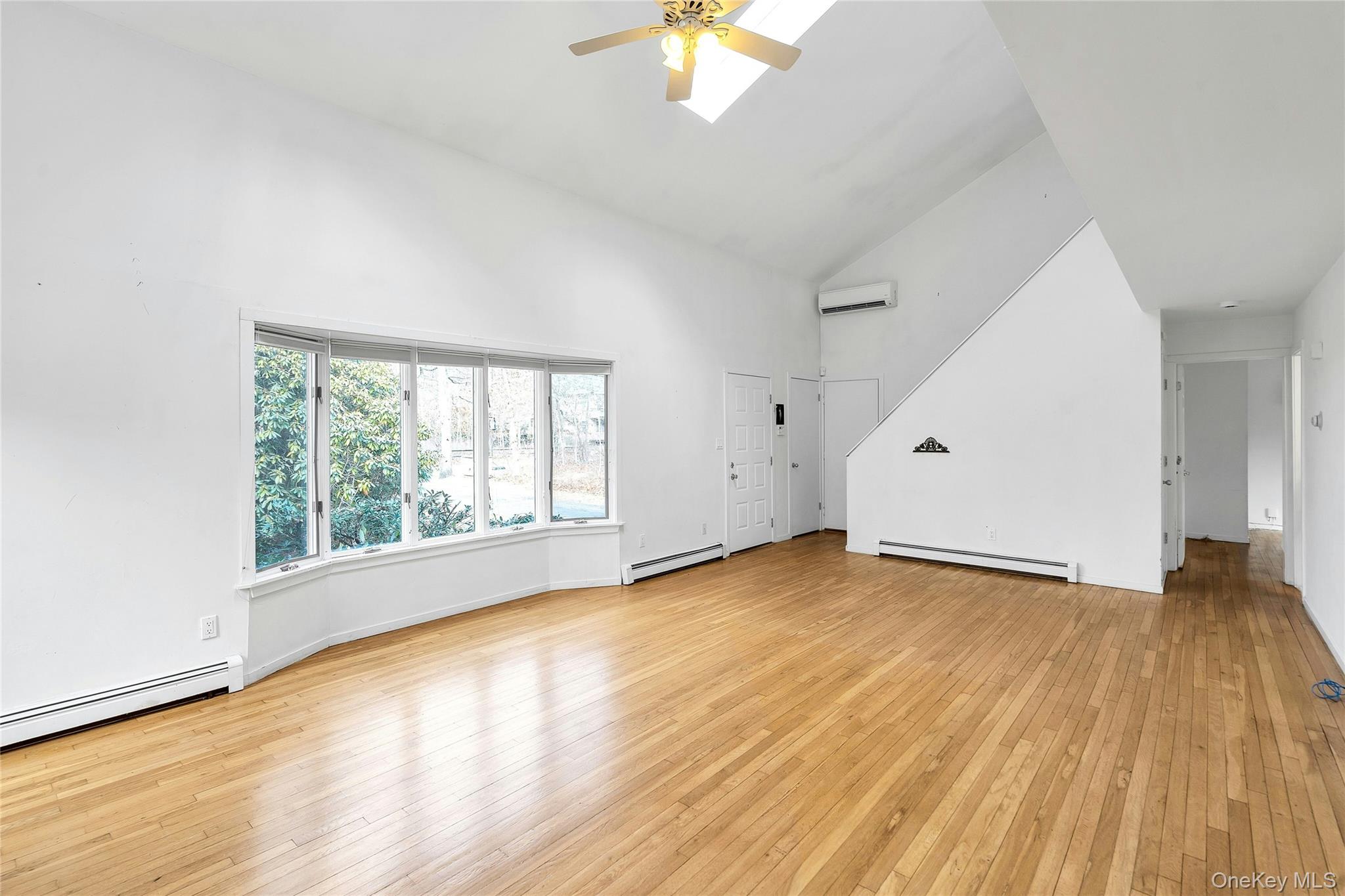 23 Bellows Terrace Hampton Bays, NY 11946 - Photo 6 of 31 an empty room with wooden floor and windows