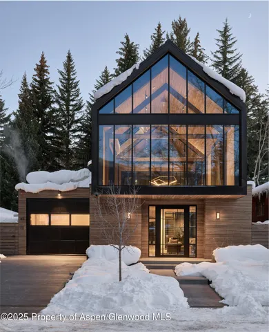a front view of a house with porch and chairs