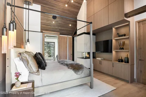 a living room with furniture a flat screen tv and a floor to ceiling window