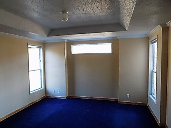 304 Tucker Road Lizella, GA 31052 - Photo 7 of 18 an empty room with wooden floor and windows with curtains