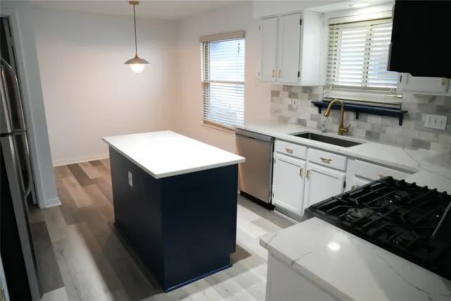 a kitchen with stainless steel appliances a sink stove and window