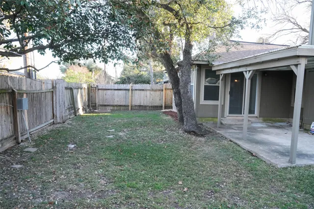 a view of a house with backyard and glass windows