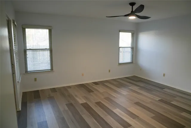 an empty room with a window and wooden floor