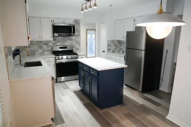 a kitchen with stainless steel appliances a refrigerator stove microwave and sink