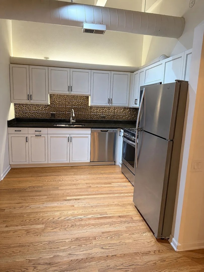312 North May Street, Unit 4H Chicago, IL 60607 - Photo 5 of 13 a kitchen with stainless steel appliances granite countertop a refrigerator sink and cabinets