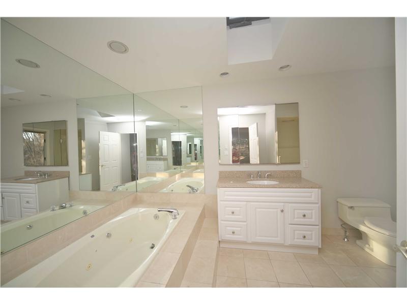 4 Locust Hill Road Darien, CT 06820 - Photo 17 of 25 a bathroom with a tub a double vanity sink and mirror