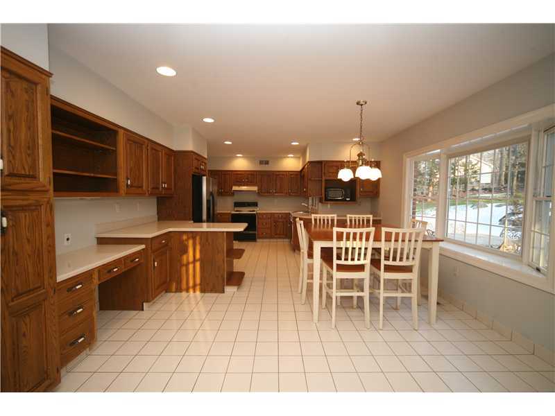 4 Locust Hill Road Darien, CT 06820 - Photo 7 of 25 a open kitchen with stainless steel appliances granite countertop a stove a refrigerator a kitchen island a dining table and chairs