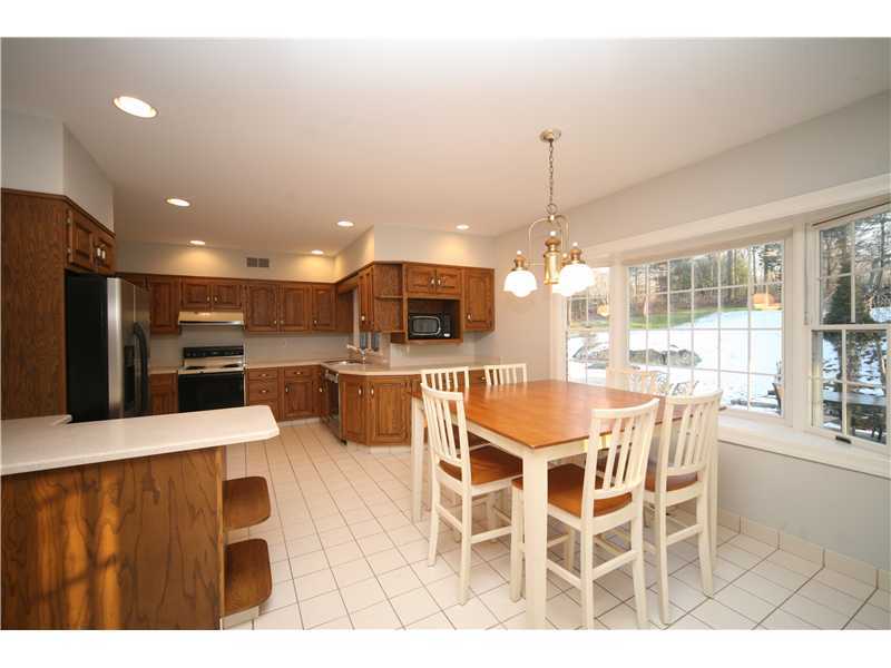 4 Locust Hill Road Darien, CT 06820 - Photo 8 of 25 a kitchen with stainless steel appliances kitchen island granite countertop a dining table chairs and white cabinets
