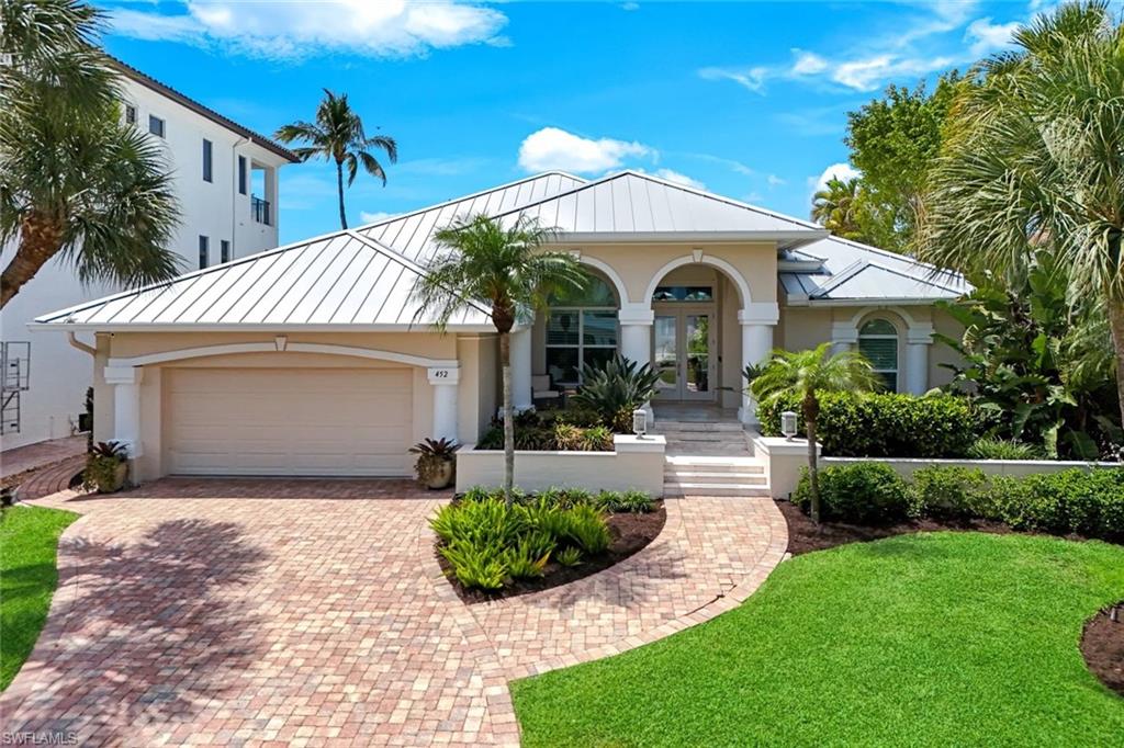 452 Willet Avenue Naples, FL 34108 - Photo 1 of 28 a front view of a house with a garden and plants