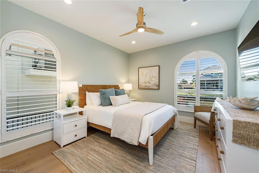 452 Willet Avenue Naples, FL 34108 - Photo 12 of 28 a bedroom with a large bed and a chandelier