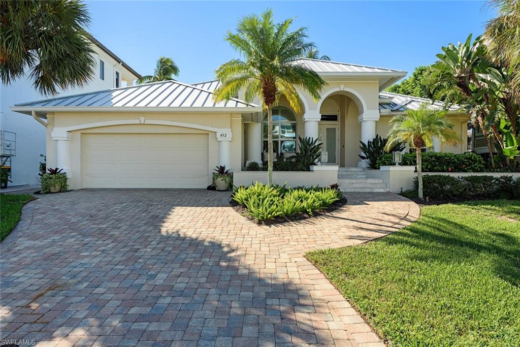 452 Willet Avenue Naples, FL 34108 - Photo 2 of 28 a front view of a house with a garden