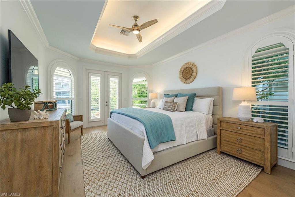 452 Willet Avenue Naples, FL 34108 - Photo 9 of 28 a bedroom with a bed and a chandelier