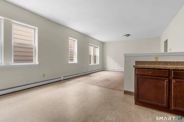 a view of an empty room with a fireplace and a window