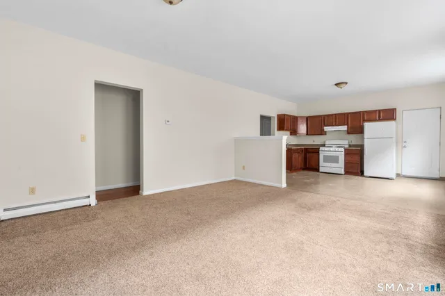 an empty room with a window and fireplace