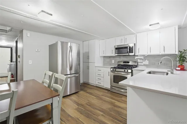 a kitchen with stainless steel appliances a stove refrigerator sink and microwave