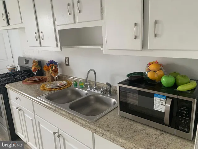 a kitchen with stainless steel appliances granite countertop a sink a stove and cabinets