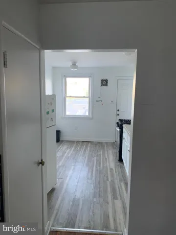 a view of a hallway with wooden floor and a cabinet