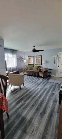 a living room with furniture and a refrigerator