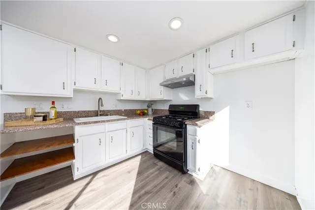 a kitchen with granite countertop white cabinets and stainless steel appliances